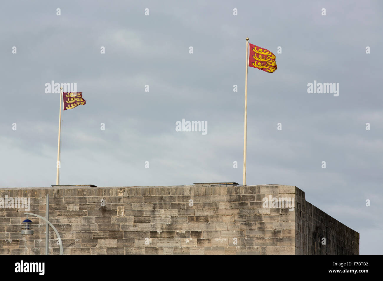 Old flags flying on top of the square tower in Old Portsmouth. Three lions on some old tatty flags. Stock Photo