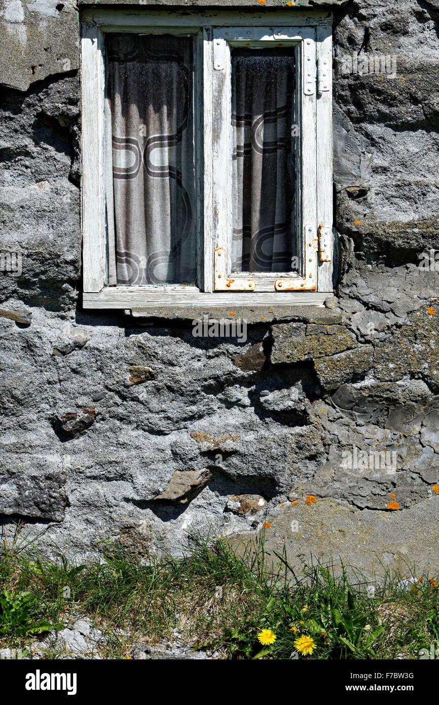 Close up detail of old wood frame window set into stone building, Iceland Stock Photo