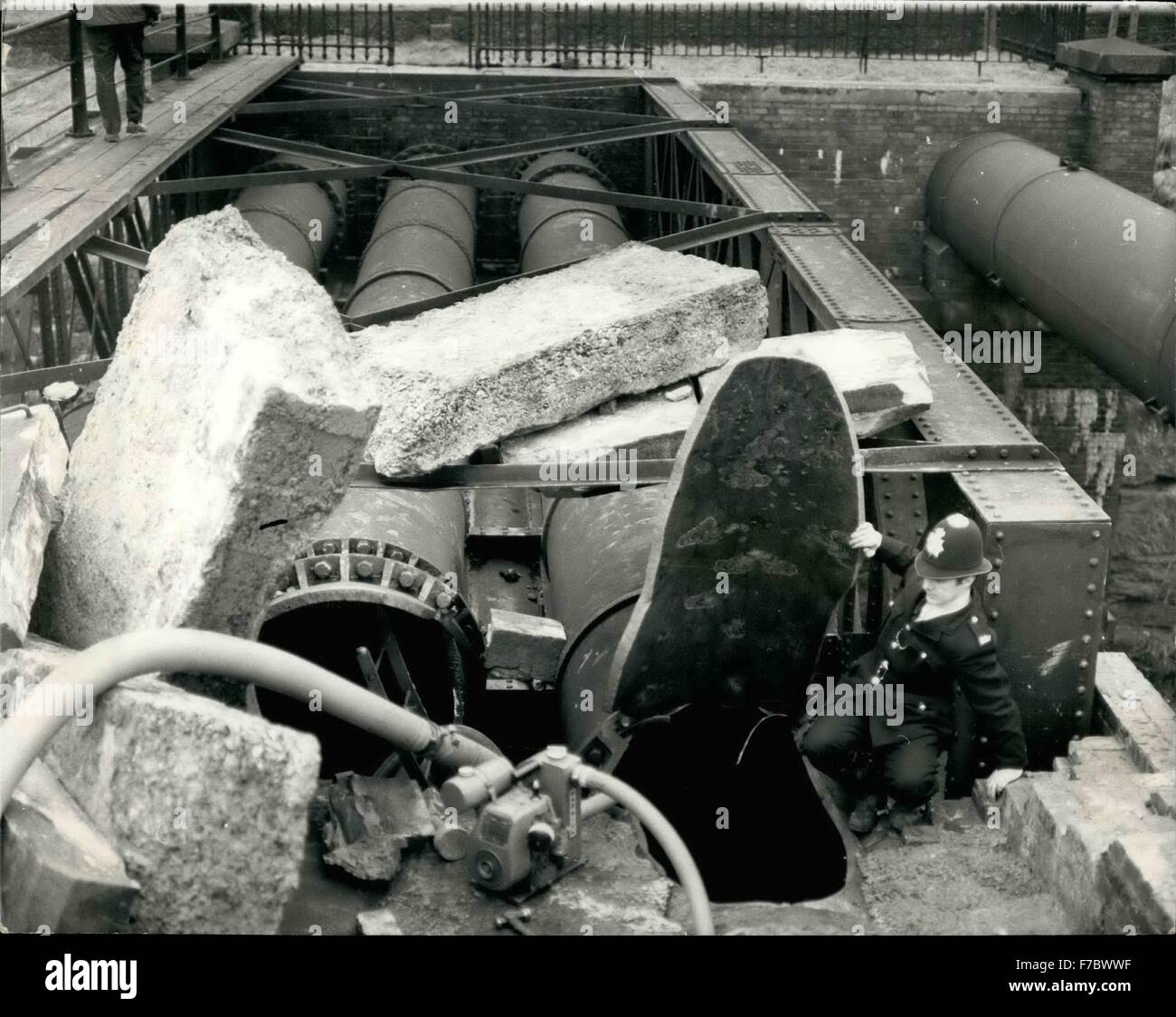 1962 - City's Pipelines Blown Up: Police began a hunt for a gang of saboteurs after two giant pipelines carrying half Birmingham's water supply from the Elan Valley, in Wales, were shattered at Hagley, Worcestershire today, in a time-bomb explosion which caused extensive flooding and cut a railway link. Photo Shows: A policeman looks into the gaping hole which was blown in the 42-inch diameter main water pipes, at Hagley, today. © Keystone Pictures USA/ZUMAPRESS.com/Alamy Live News Stock Photo