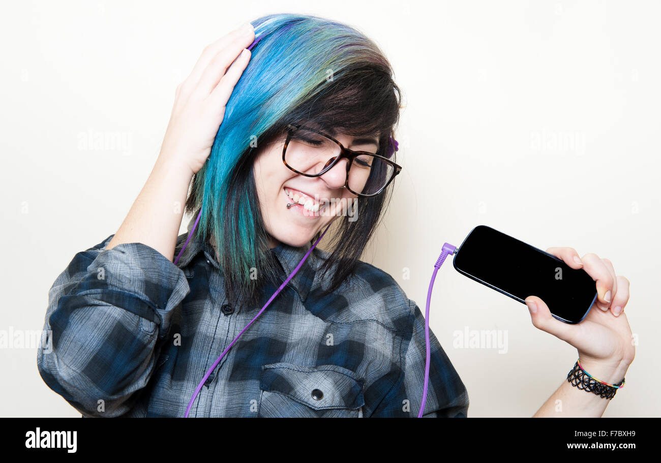 Pretty young teen woman with mobile phone listening music on white Stock Photo