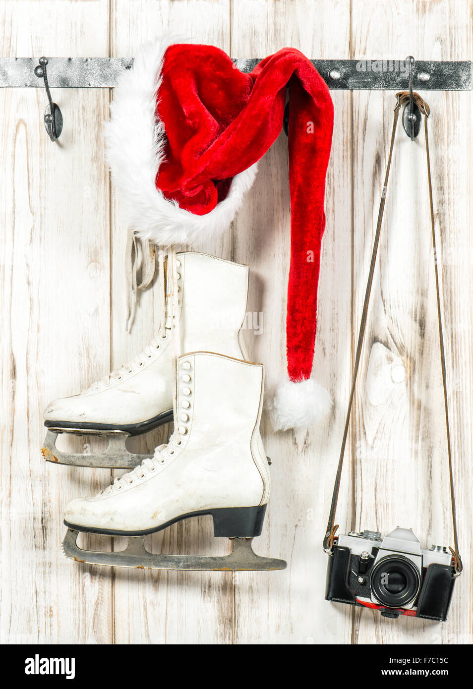 Christmas decoration. Red hat, retro photo camera and white ice skates. Vintage style toned picture Stock Photo