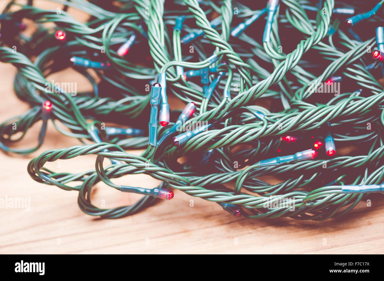 red Christmas lights cord bundle close up wood background Stock Photo