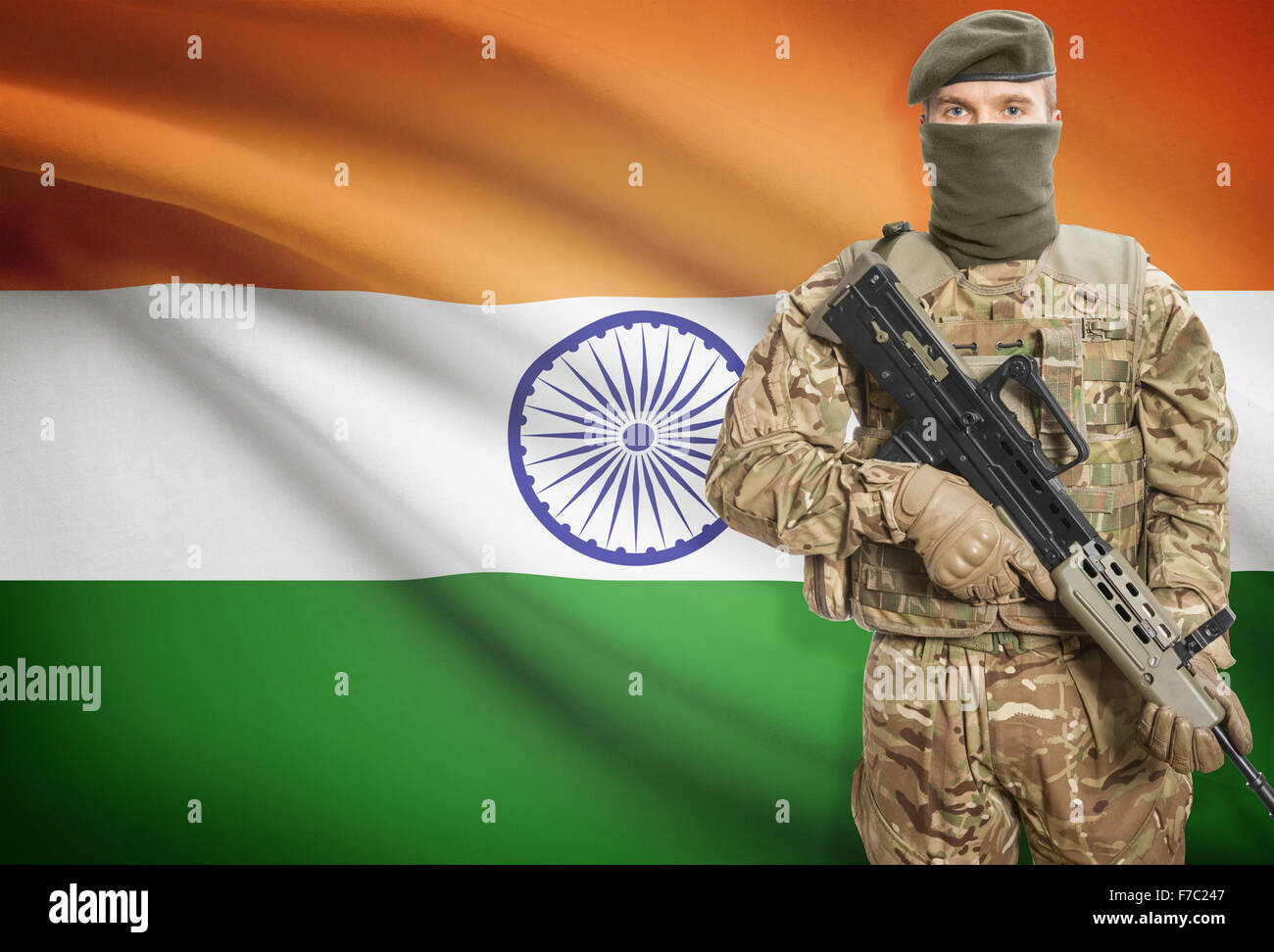 Soldier holding machine gun with national flag on background - India Stock  Photo - Alamy