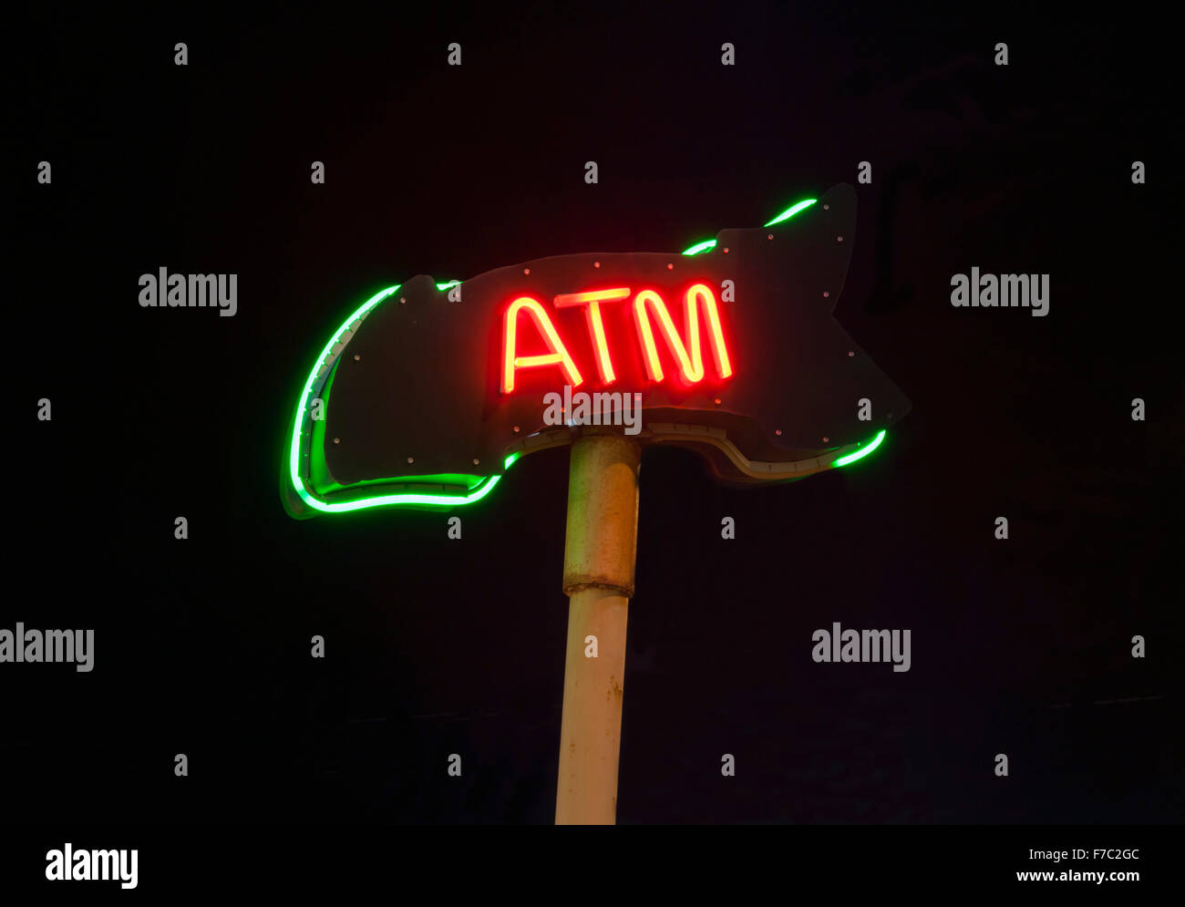 Neon ATM sign isolated on black background Stock Photo - Alamy