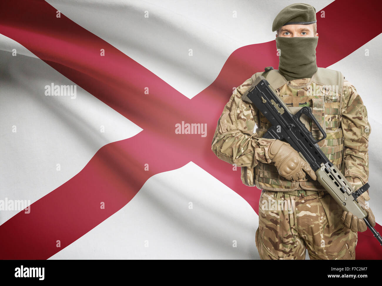 Soldier holding machine gun with USA state flag on background - Alabama Stock Photo