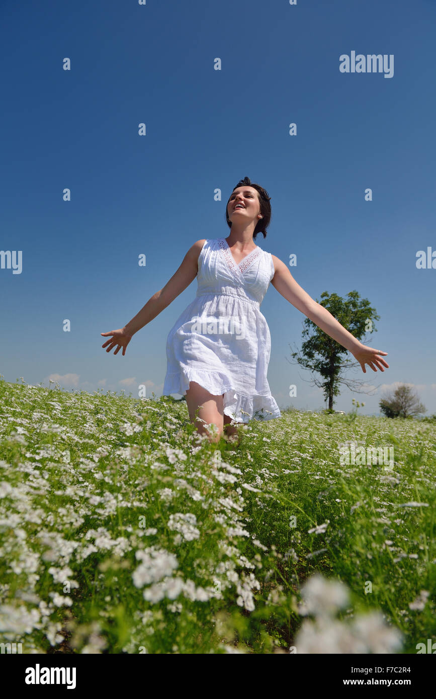Young happy woman in green field with blue sky in background Stock ...