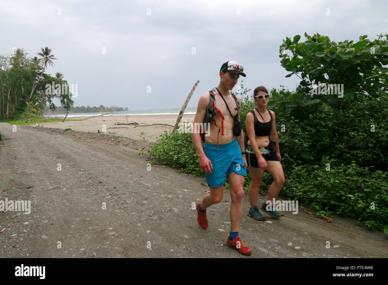 (151129) -- LIMON, Nov. 29, 2015 (Xinhua) -- Image taken on Nov. 24, 2015 shows foreign tourists walking on the section of a road that was partially destroyed along the beach, in Cahuita National Park, in Limon Province, southern Costa Rica. According to the ranger Cristian Brenes, rising sea levels and strong waves due to climate change have removed nearly 50 meters of beach along the coast of Cahuita National Park. The case of Cahuita National Park is not the only one in Costa Rica, which has 1,290km of coastline. More than 40 percent of Costa Rican beaches have erosion, a process that has a Stock Photo