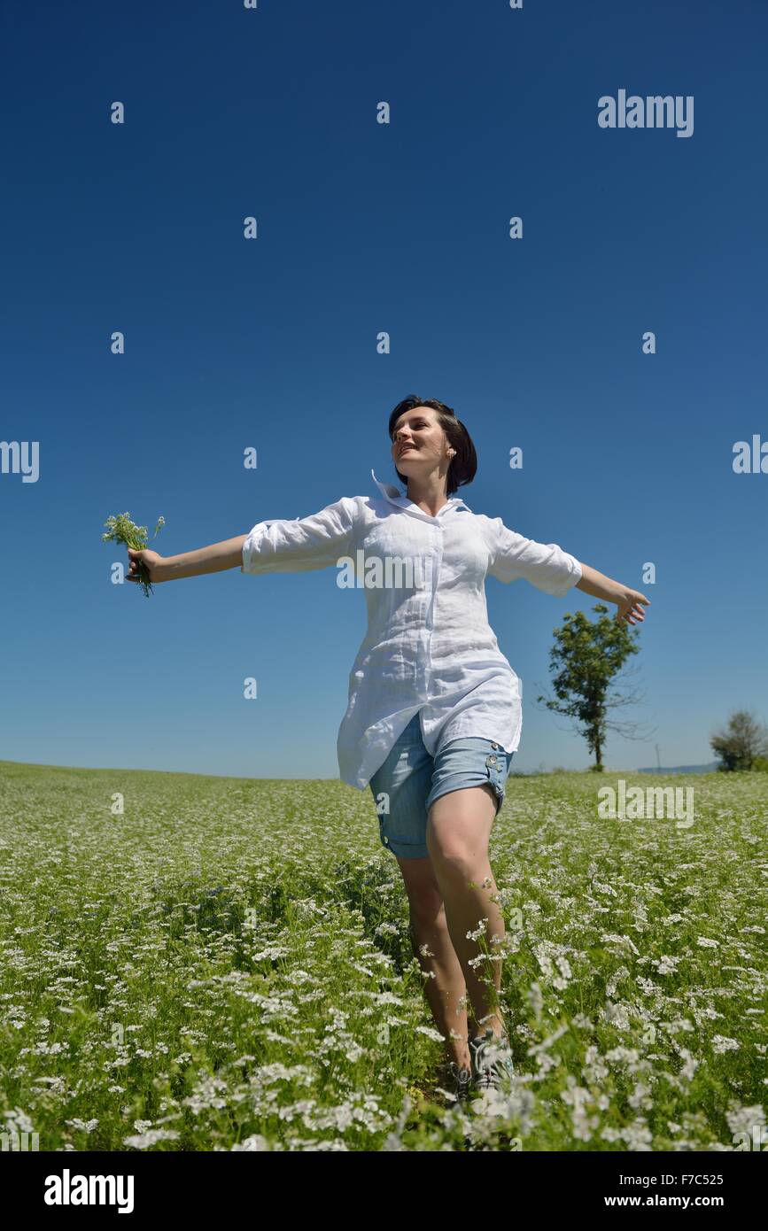 Young happy woman in green field with blue sky in background Stock ...