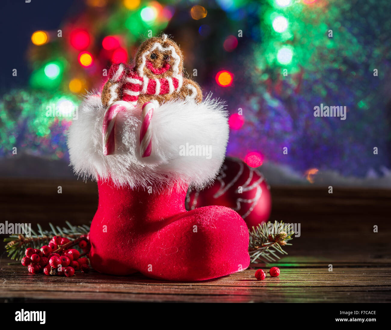 Christmas red boot in candle light across from the frozen window. Stock Photo