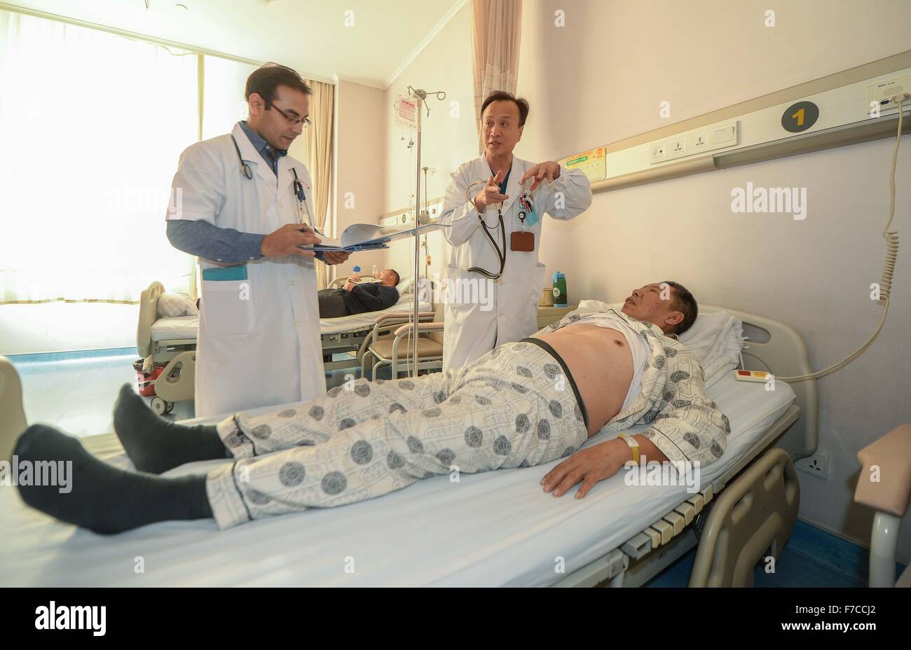 Changchun, China's Jilin Province. 26th Nov, 2015. Kumar Adhikari (1st L), a medical student from Nepal, conducts medical check with his PhD Supervisor at the First Hospital of Jilin University in Changchun, capital of northeast China's Jilin Province, Nov. 26, 2015. Adhikari, 30, has lived in China for 10 years to study cardiovascular medicine. He now is a PhD student at the Norman Bethune Health Science Center of Jilin University. A total of 528 foreign students studied medicine at the center, most of whom come from Asia and African nations. © Wang Haofei/Xinhua/Alamy Live News Stock Photo