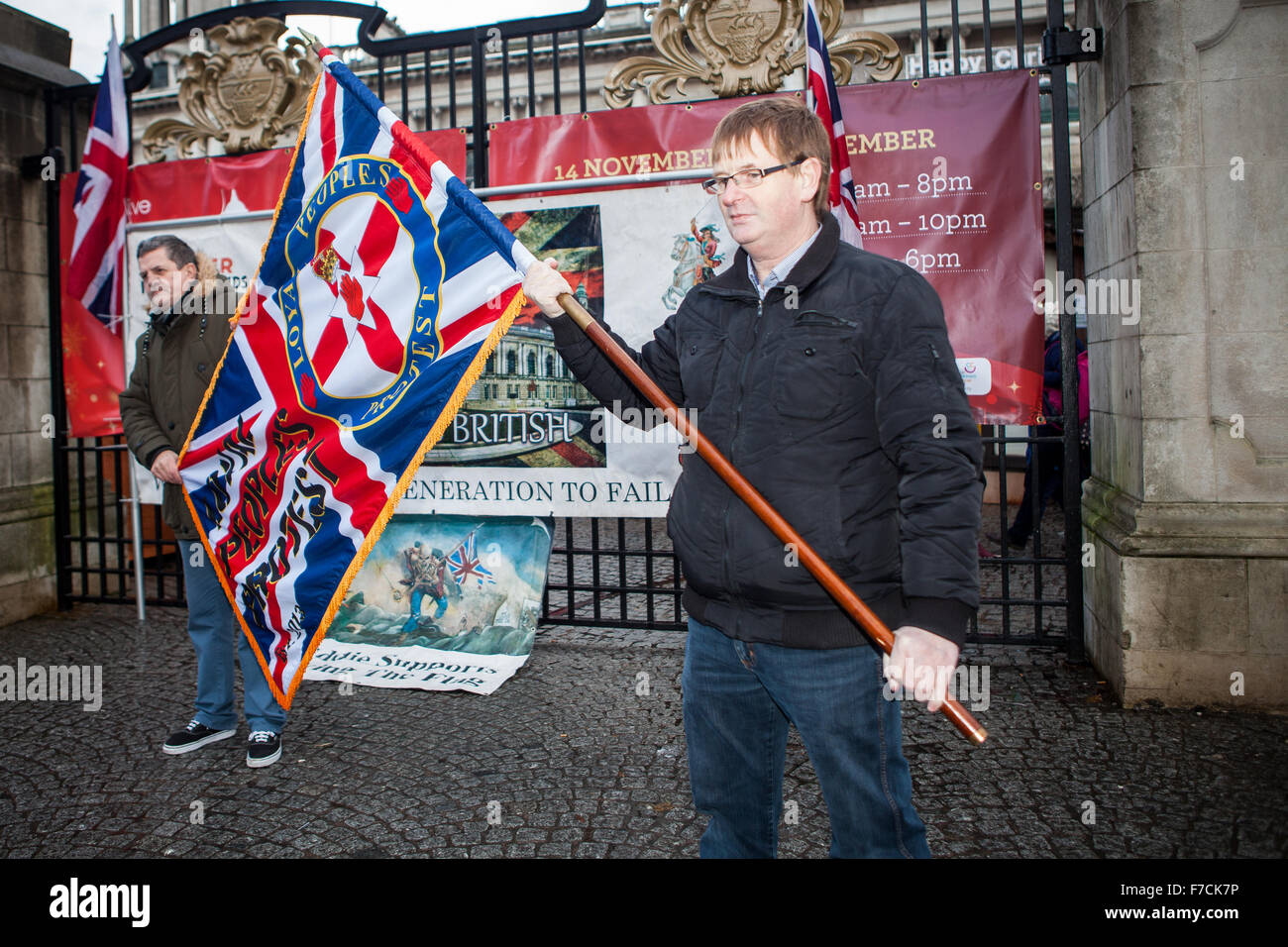 Belfast, UK. 28th November, 2015. Willie Frazer (R) Holding Loyal People Protest flag at the 3rd Anniversary decision of  Belfast City Council to restrict the flying of the union flag to 18 days per year. Mr Frazer is the founder and leader of the pressure group Families Acting for Innocent Relatives (FAIR). Credit:  Bonzo/Alamy Live News Stock Photo
