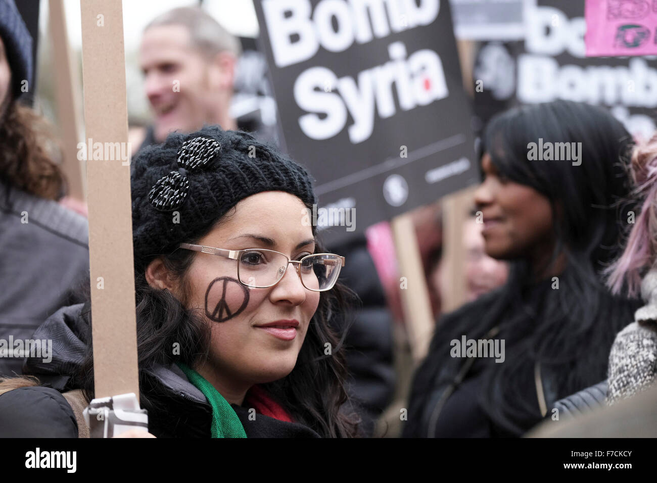 A demonstrator with a peace symbol drawn on her face amongst protesters gathering opposite Downing Street in London to protest Stock Photo