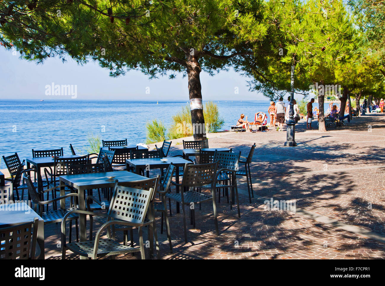 Trieste, Italy, beautiful summer view of Barcola free strand with coffee bar and people sun bathing Stock Photo