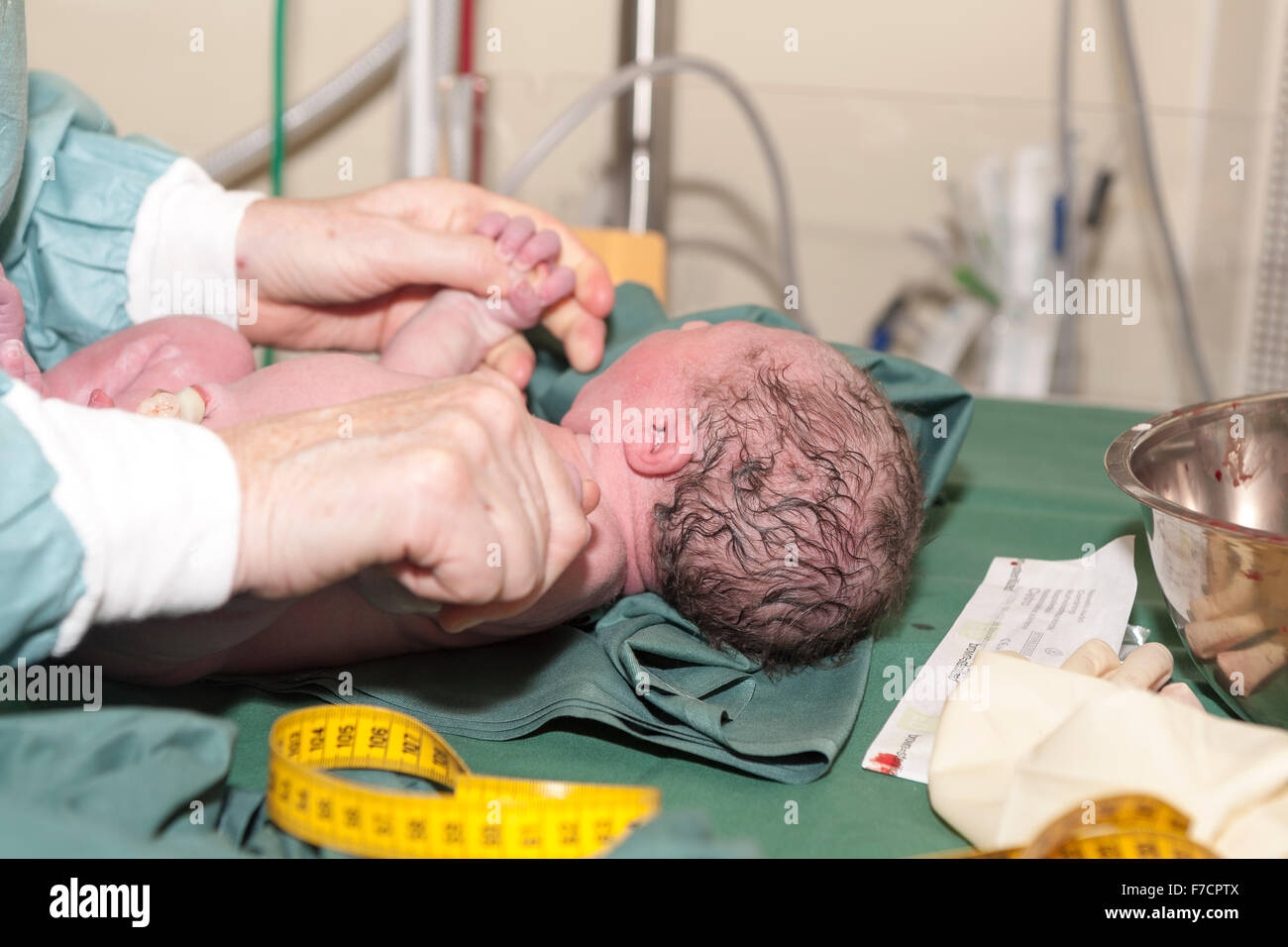 Newborn baby boy having his first medical examination after caesarean