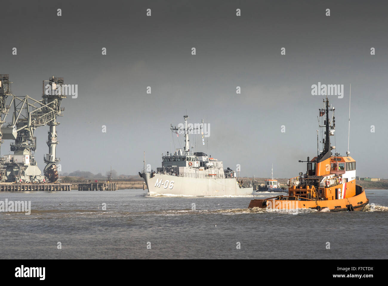 The Boss Tug passes the NATO Alkmaar-class minehunter, LVNS Talivaldis (M-06) on the River Thames. Stock Photo