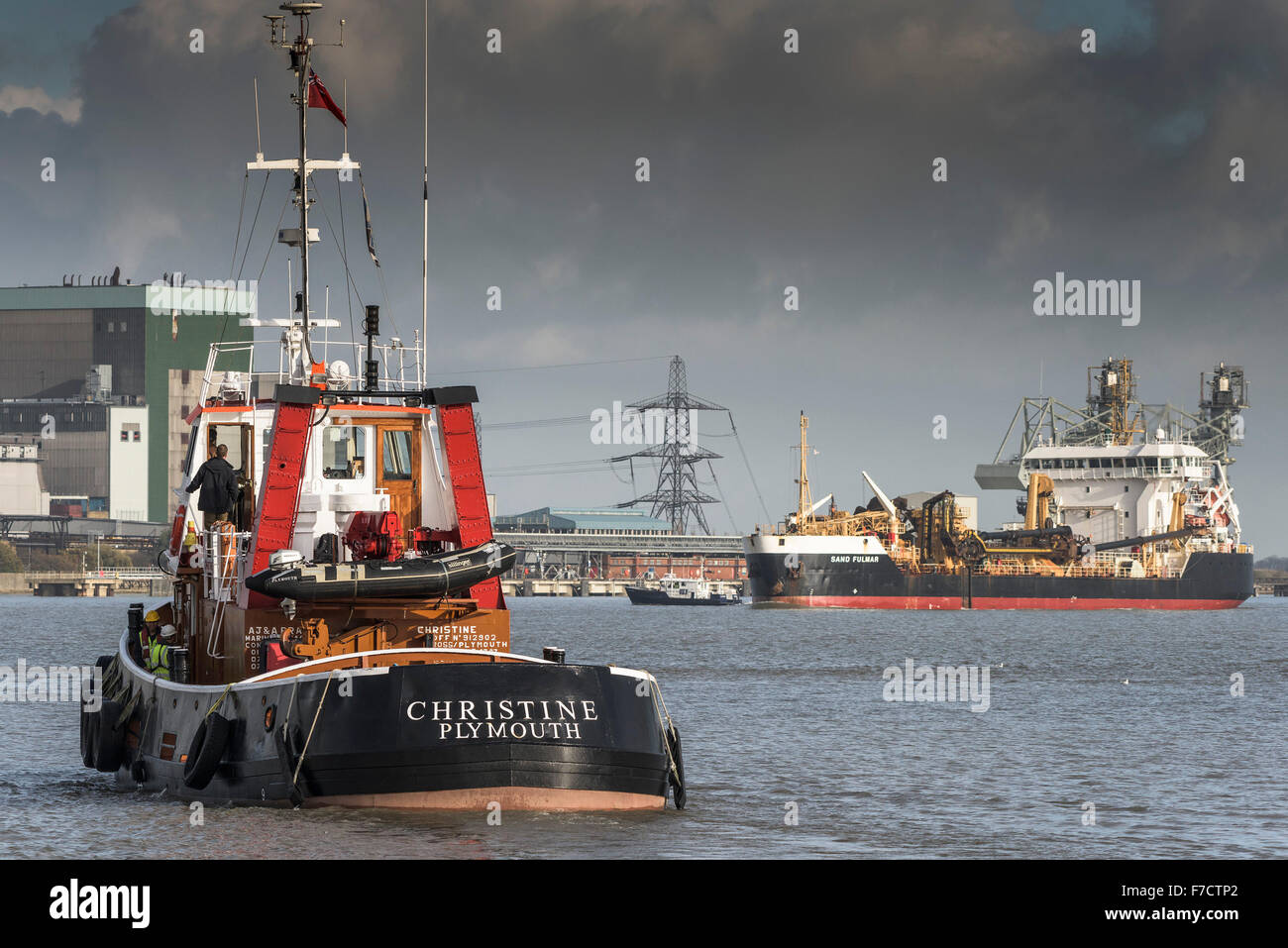 The tug Christine sets out to escort the dredger Sand Fulmar as she steams upriver on the River Thames. Stock Photo