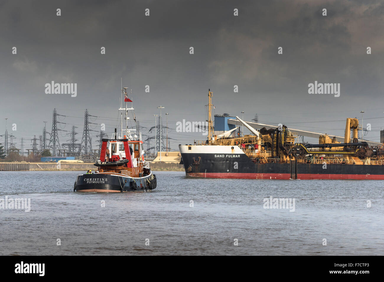 The tug Chtristine sets out out to escort the dredger, Sand Fulmar as she steams upriver on the River Thames. Stock Photo