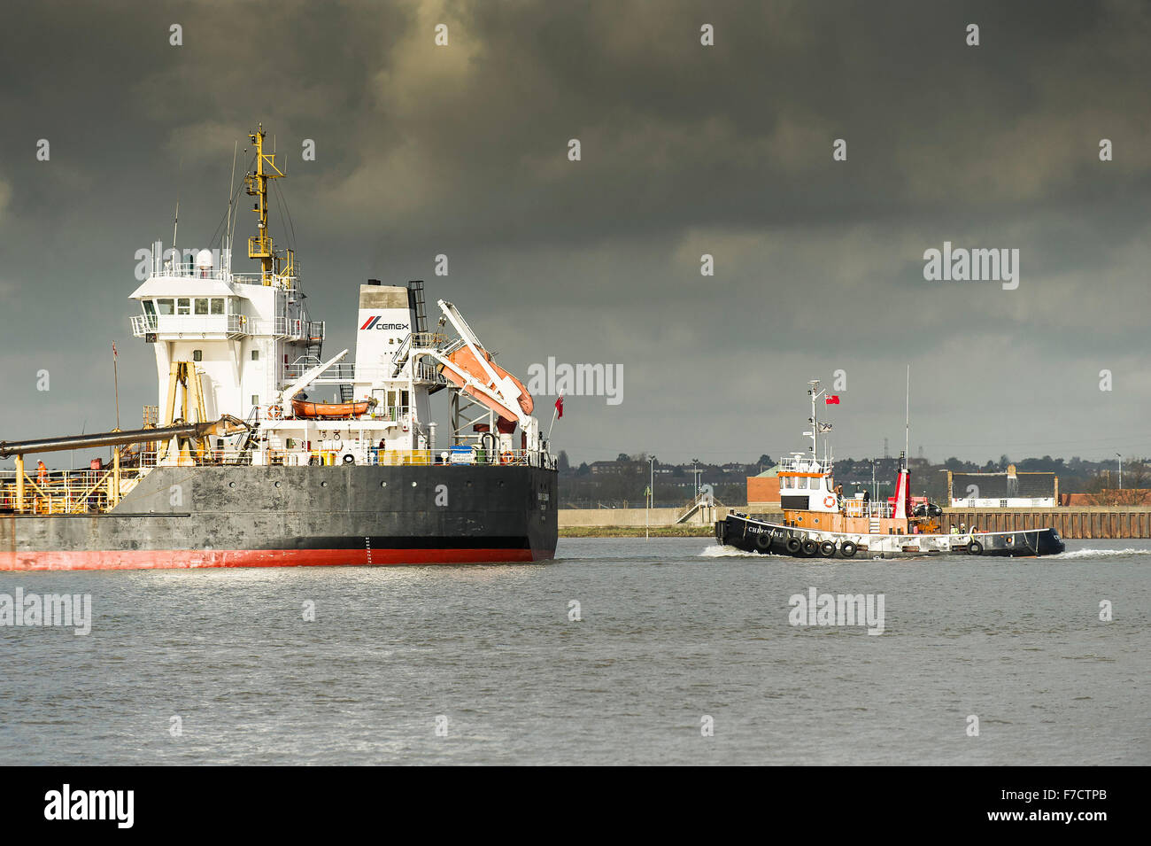 The Hopper dredger Sand Fulmar is escorted by the tug, Christine steaming upriver on the River Thames. Stock Photo
