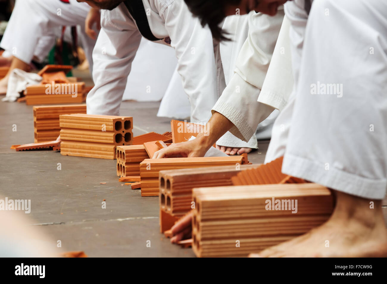 Few karate students show their skills by breaking bricks Stock Photo