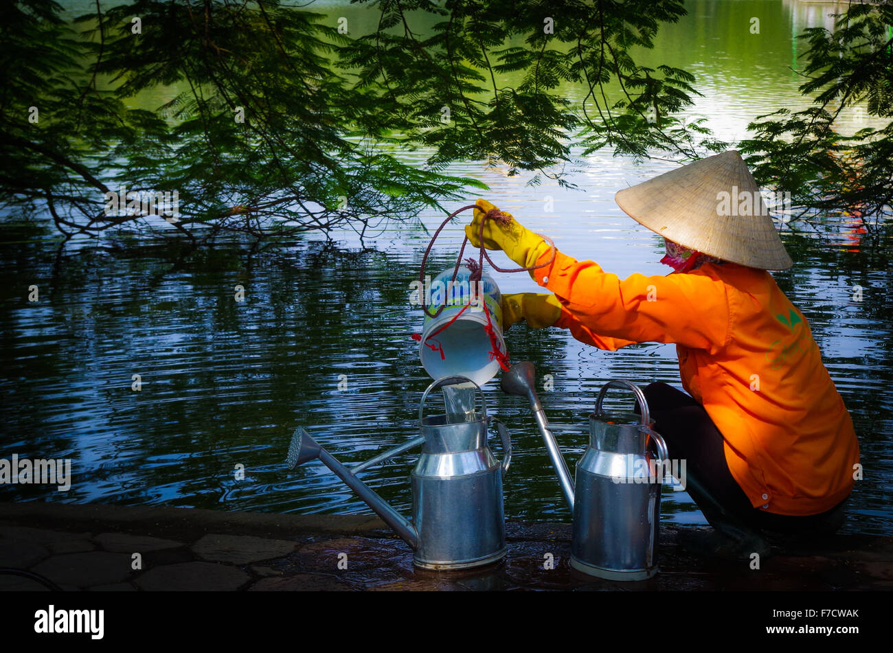 Woman with traditional dress in front of Hoan Kiem Lake in Hanoi Stock Photo