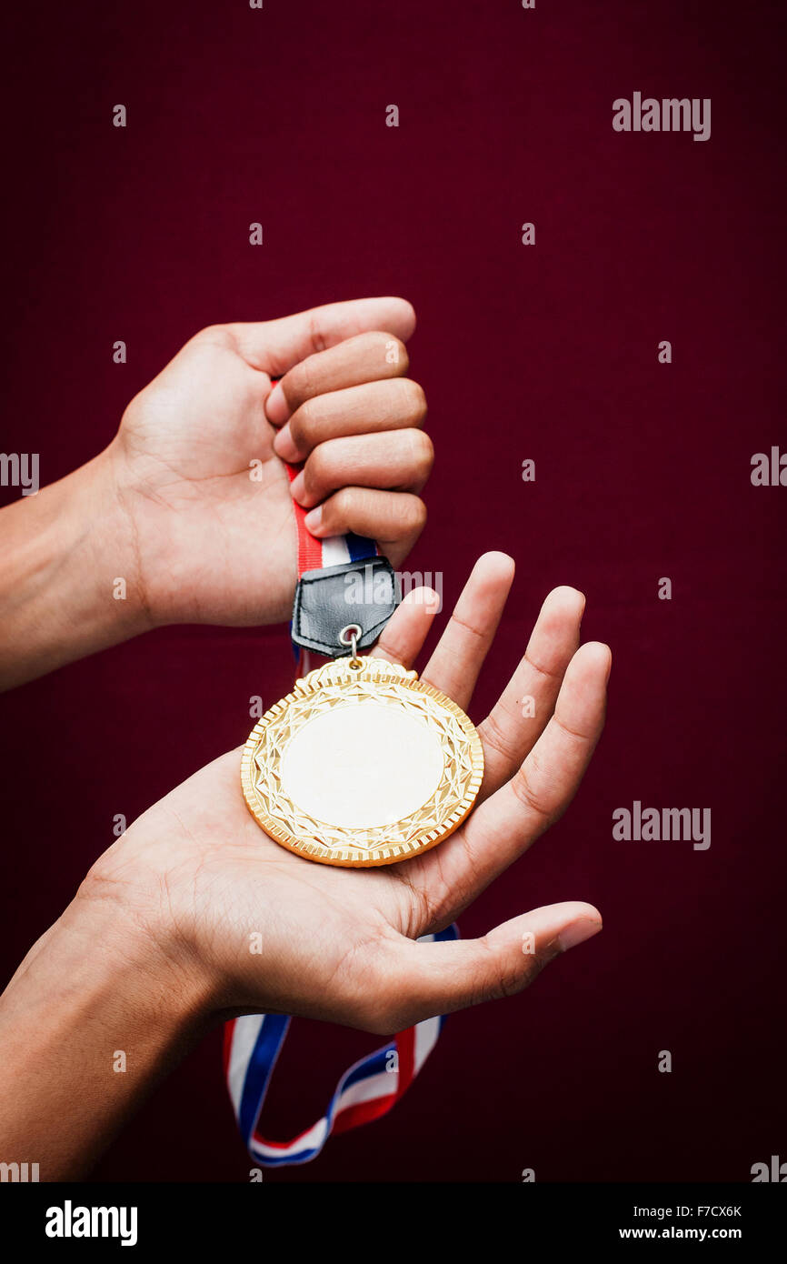 hand holding up a gold medal as a winner in a competition Stock Photo