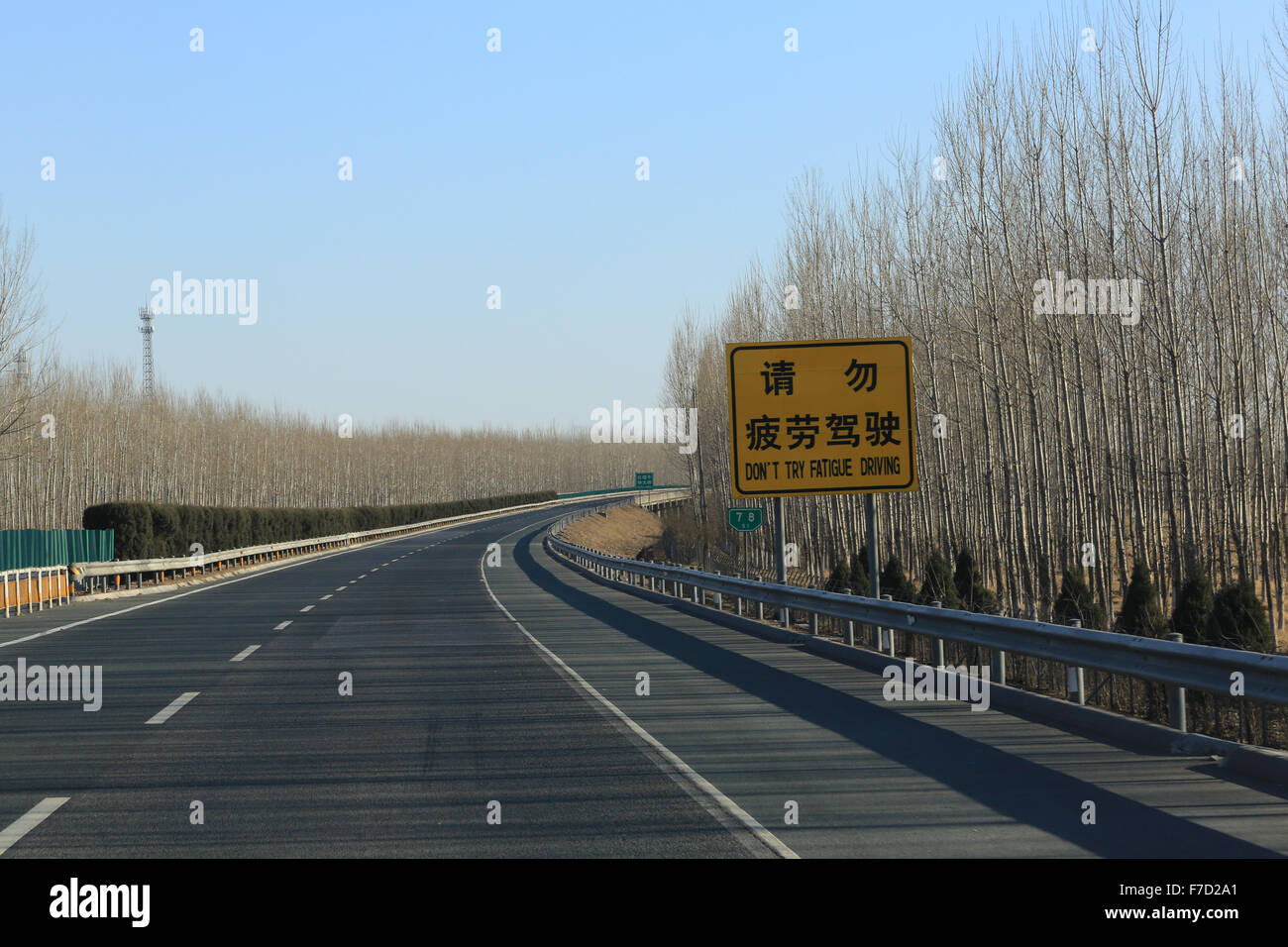 Chinese road sign: Don't Try Fatigue Driving.  Jinji Expressway headed north toward Great Wall. Stock Photo
