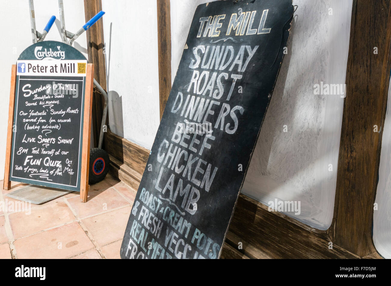 Signs outside an English pub in a Spanish holiday resort advertising Sunday Roast and other English meals. Stock Photo