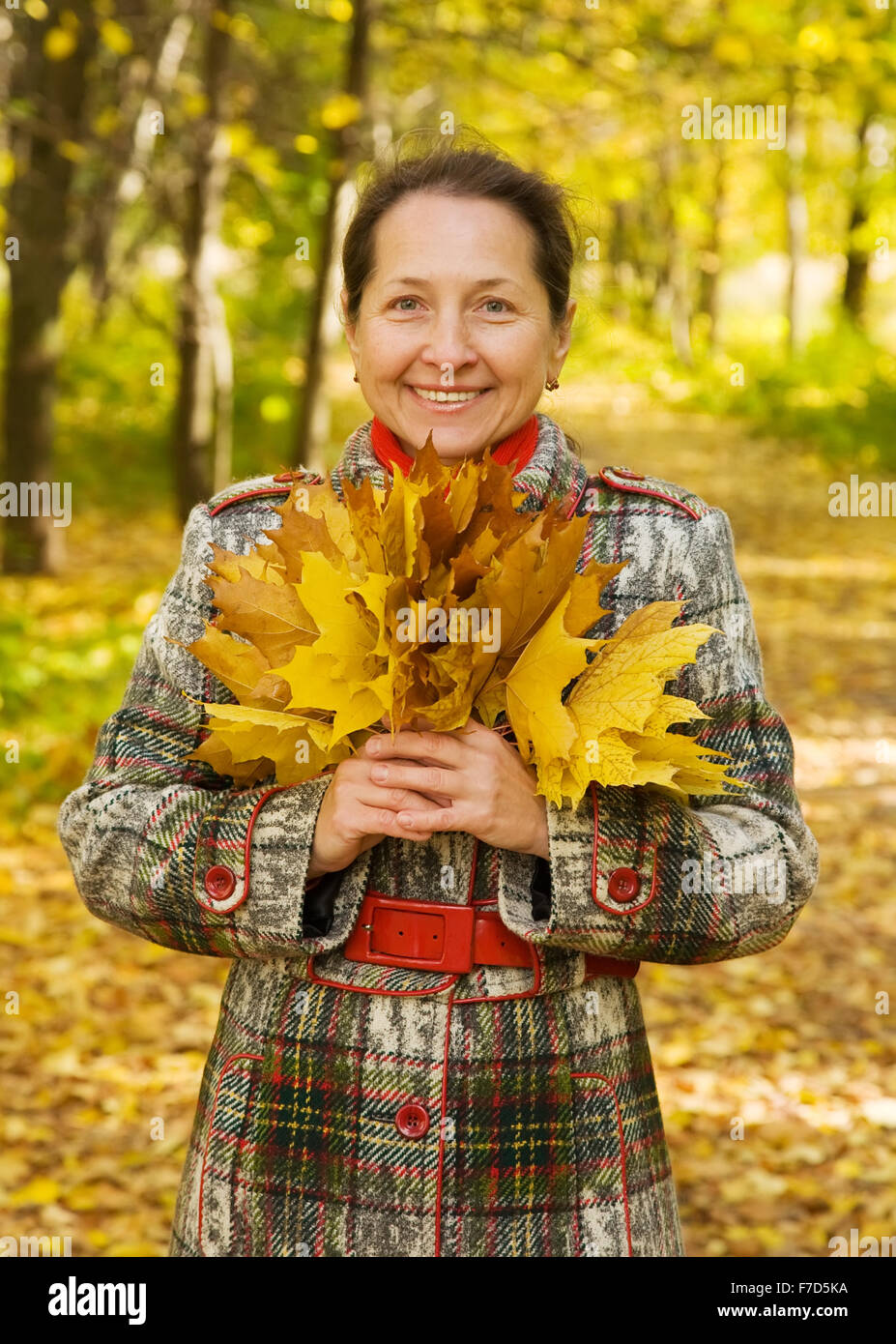 Portrait of senior woman with maple leaves in autumn park Stock Photo ...