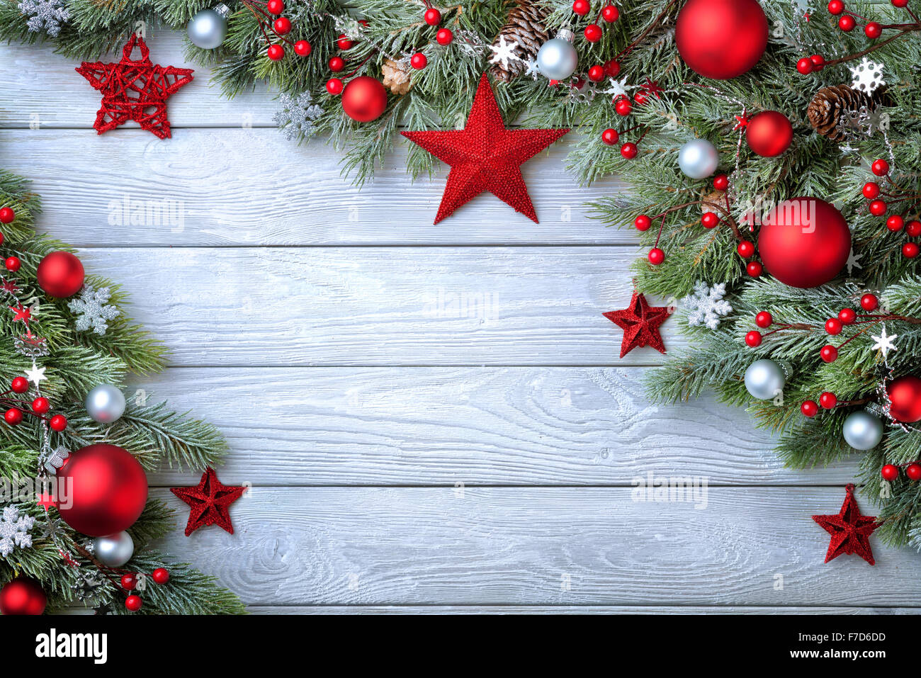 Christmas background with blue wooden board and fir branches decorated with red and silver baubles and stars - modern, simple an Stock Photo