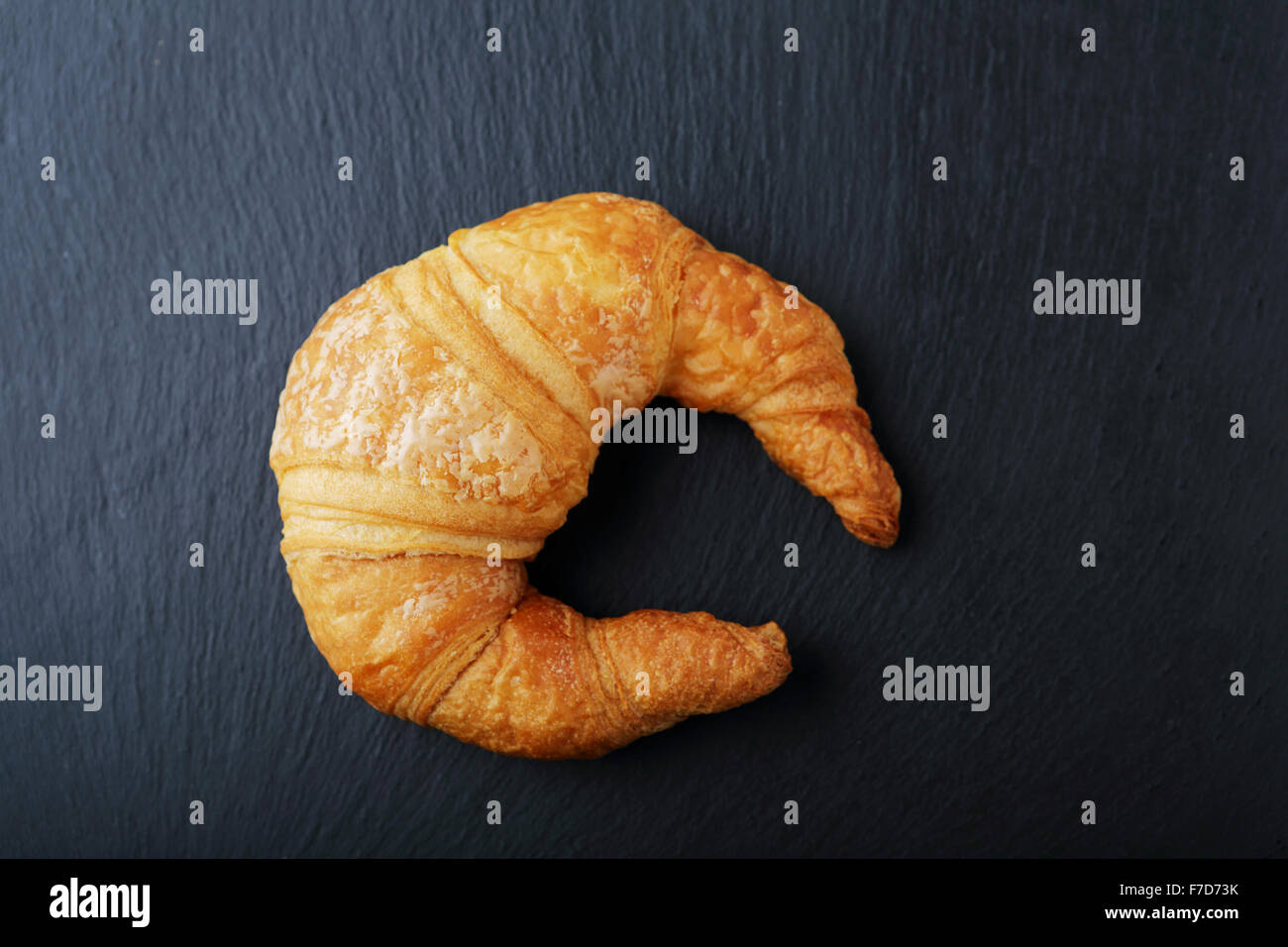 fresh golden croissant on dark background, food top view Stock Photo