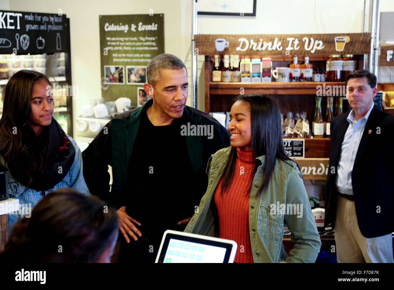 Washington, DC. 28th Nov, 2015. United States President Barack Obama buys ice cream popsicles for his daughters, Malia (L) and Sasha (R) at Pleasant Pops Farmhouse Market and Cafe in Northwest Washington, DC in support of Small Business Saturday, on November 28, 2015, in Washington, DC. Credit: Aude Guerrucci/Pool via CNP - NO WIRE SERVICE - © dpa/Alamy Live News Stock Photo