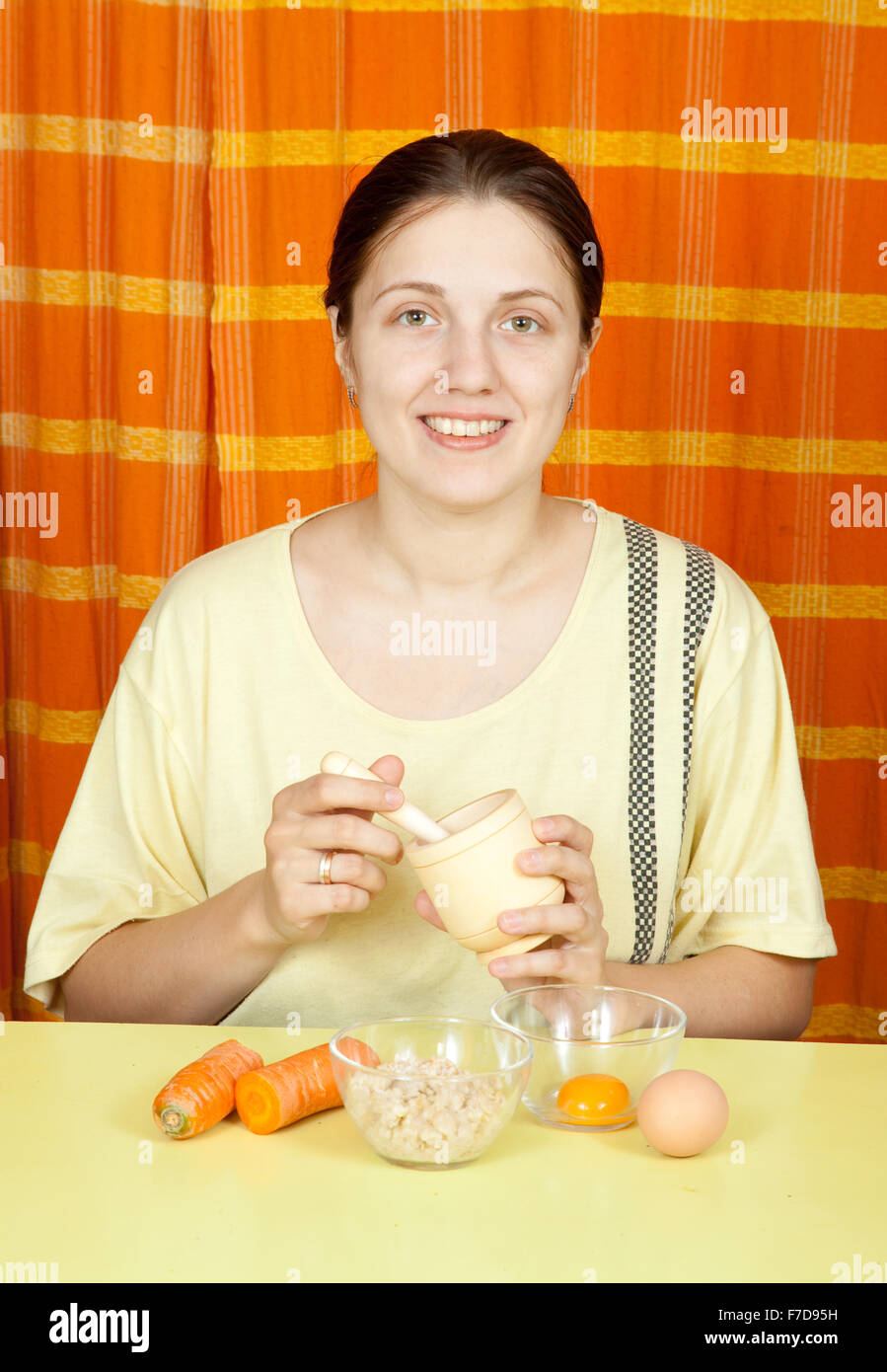 woman making  face-pack from carrot, oatmeal and egg yolk Stock Photo