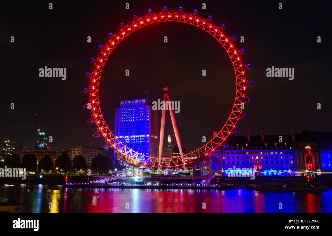 The London Eye lit red as part of the 100 year commemoration of WW1 as seen from the north bank Stock Photo