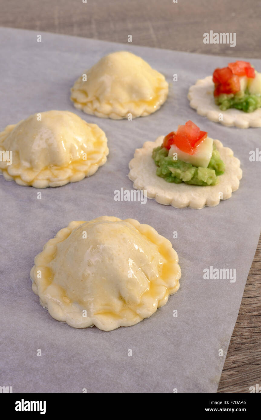 Stuffed avocado with cheese and tomato on a slice of puff pastry Stock Photo
