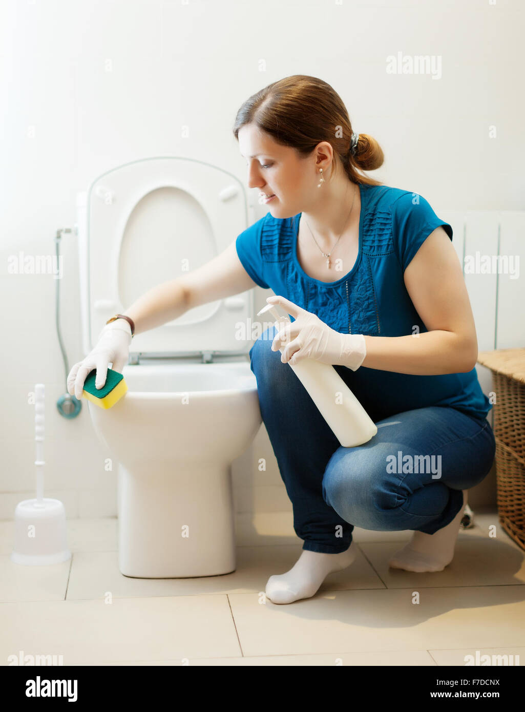 Woman cleaning toilet with sponge and cleaner at home Stock Photo Alamy