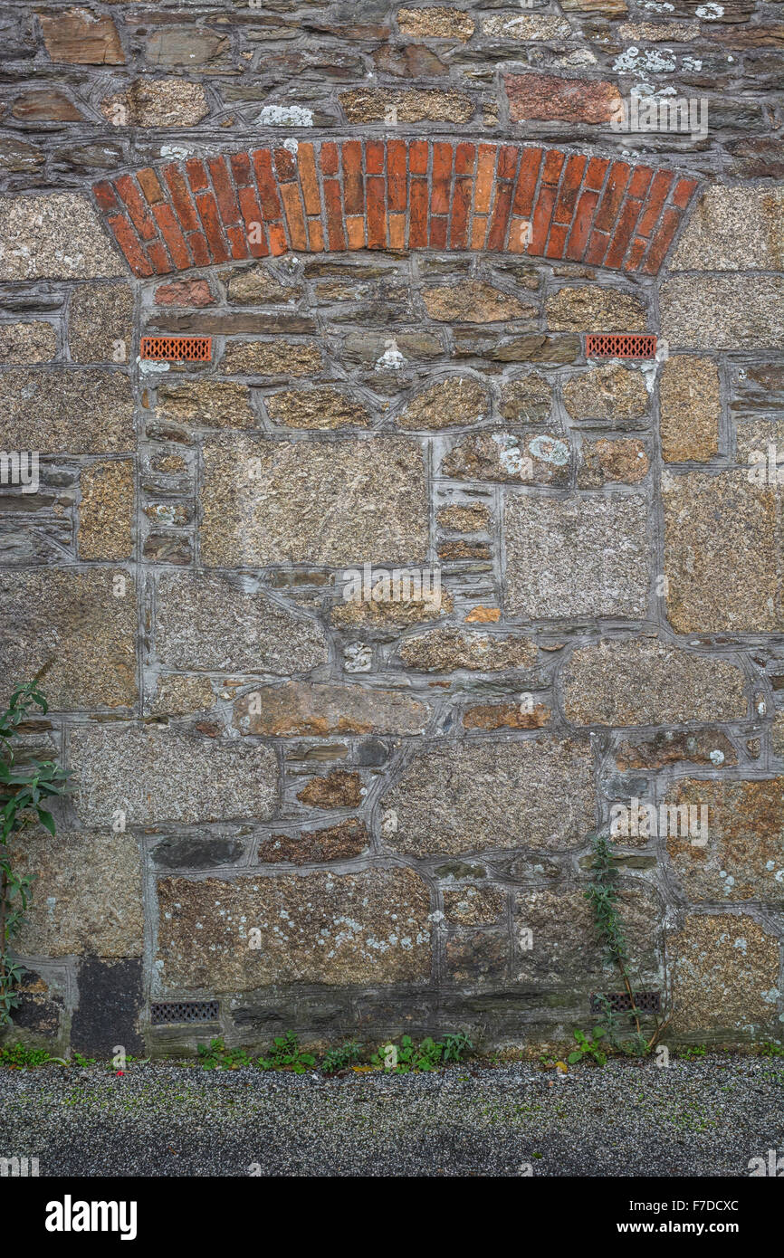 Bricked up doorway in a stone gable wall. Stock Photo