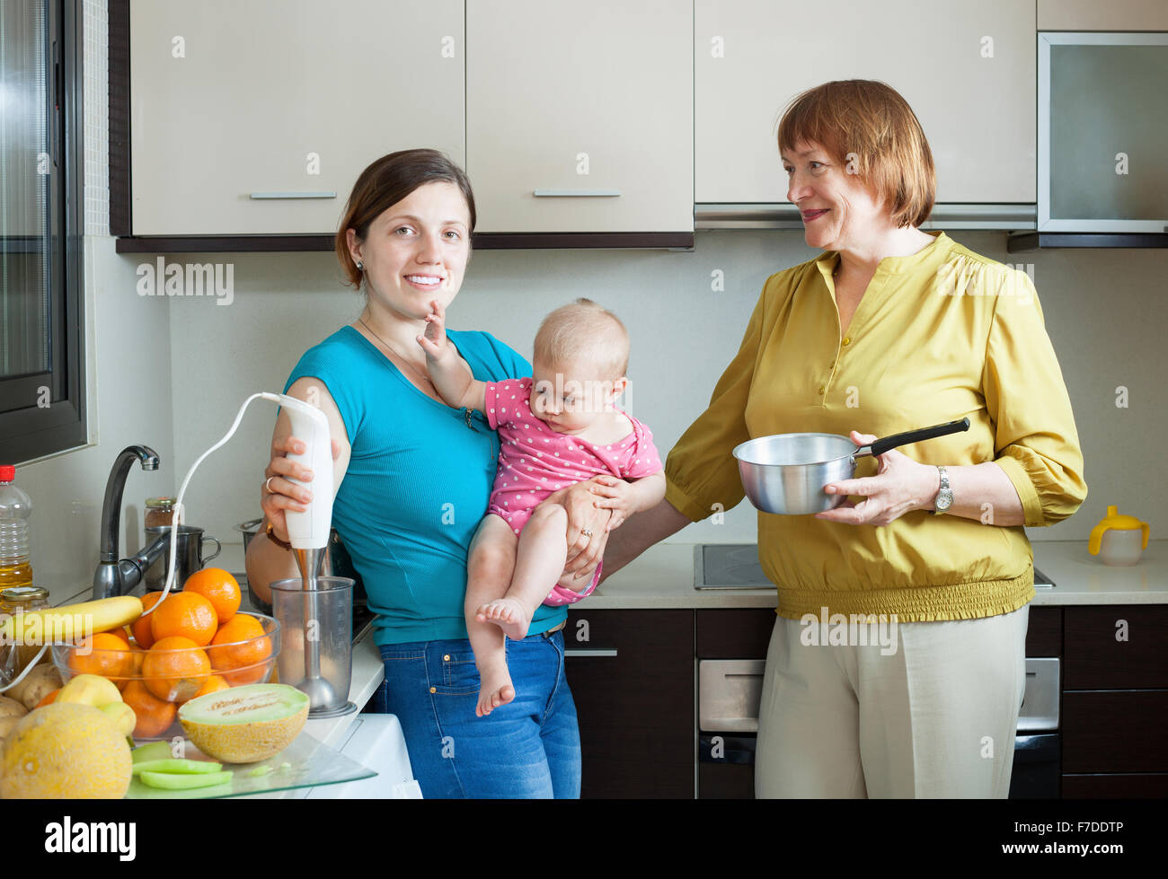 Happy women of three generations with blender in  kitchen Stock Photo