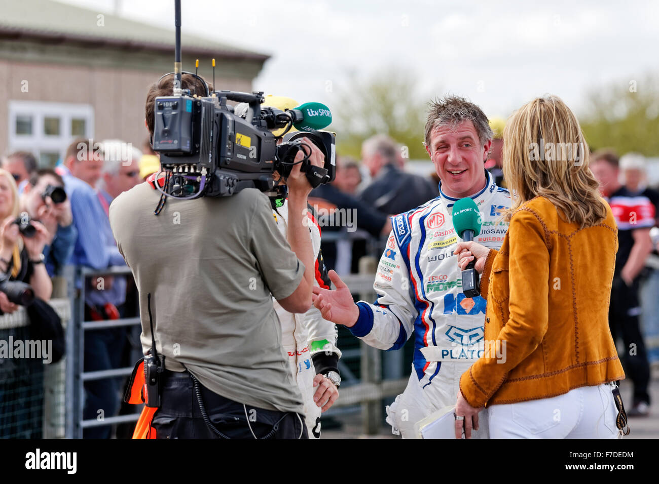 British Touring car racing driver Jason Plato being  interviewed at Thruxton race circuit by itv sports commentator Louise Goodman. Stock Photo