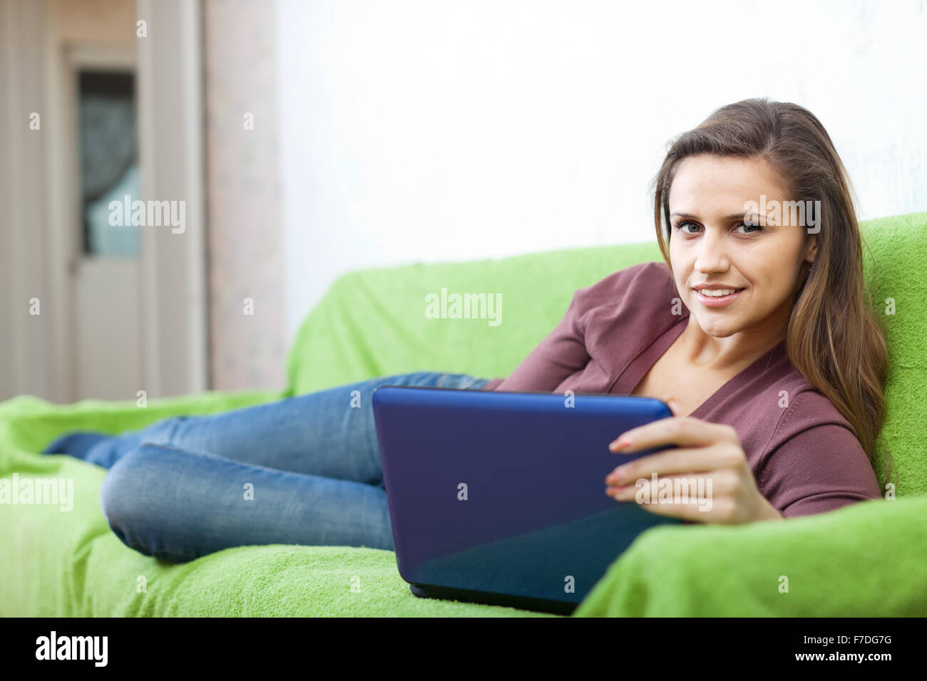 pretty young woman with laptop on sofa Stock Photo - Alamy