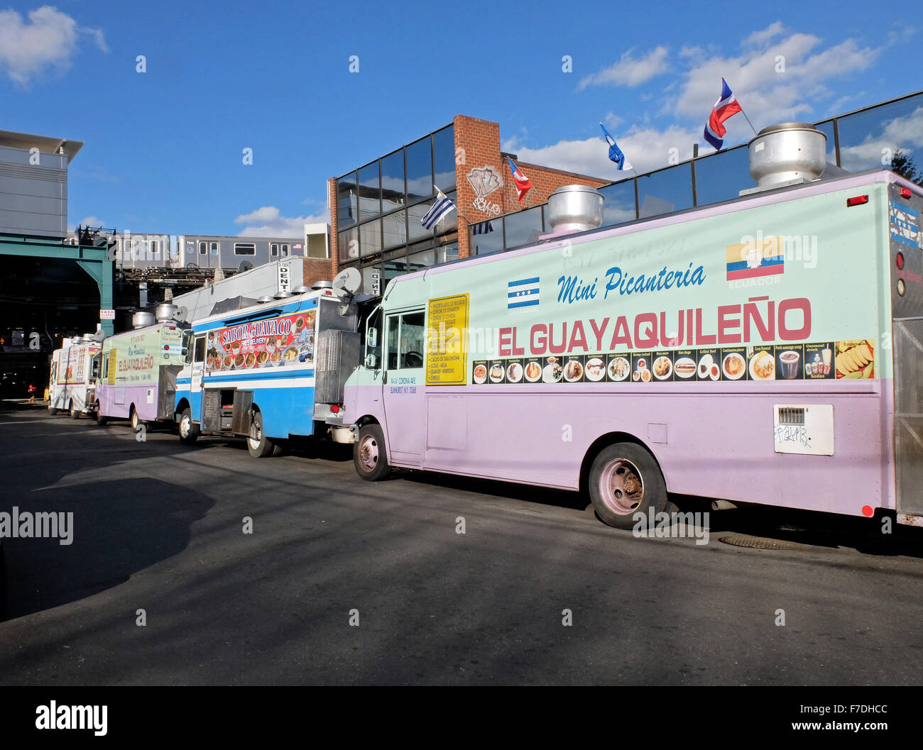 4 South American food trucks parked in the shadows of the #7 elevated train on Warren Street off Roosevelt Ave. in Queens, NYC Stock Photo