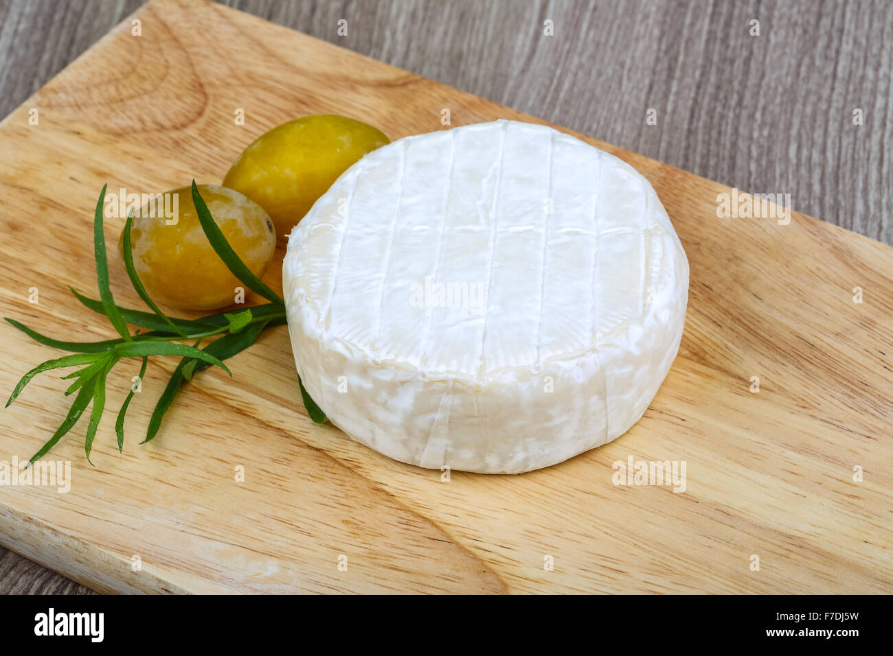 Brie cheese with yellow plums and estragon leaves Stock Photo Alamy