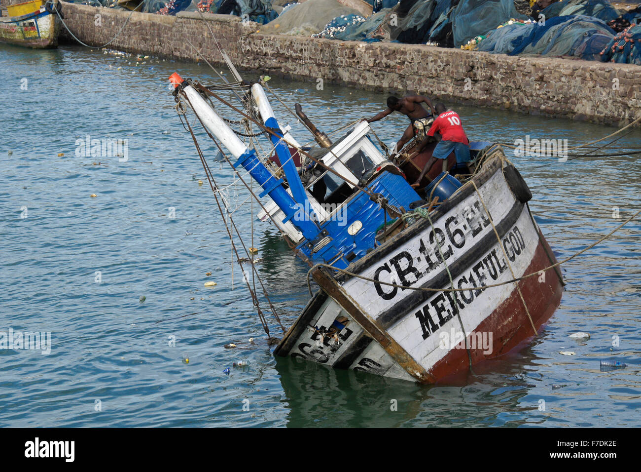 Fishing boat sinking in harbor, Cape Coast, Ghana Stock Photo