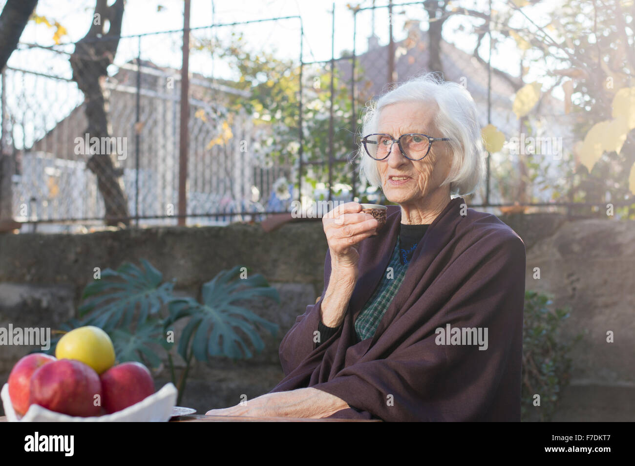 90 years old grandma having cup of coffee outdoors Stock Photo