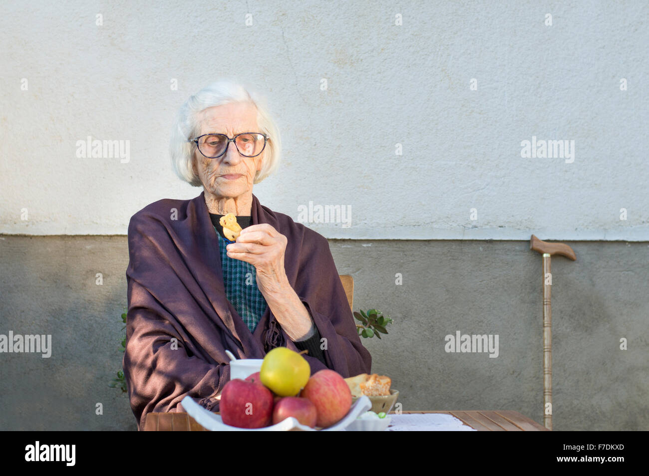 90 years old grandma having a snack in the backyard Stock Photo