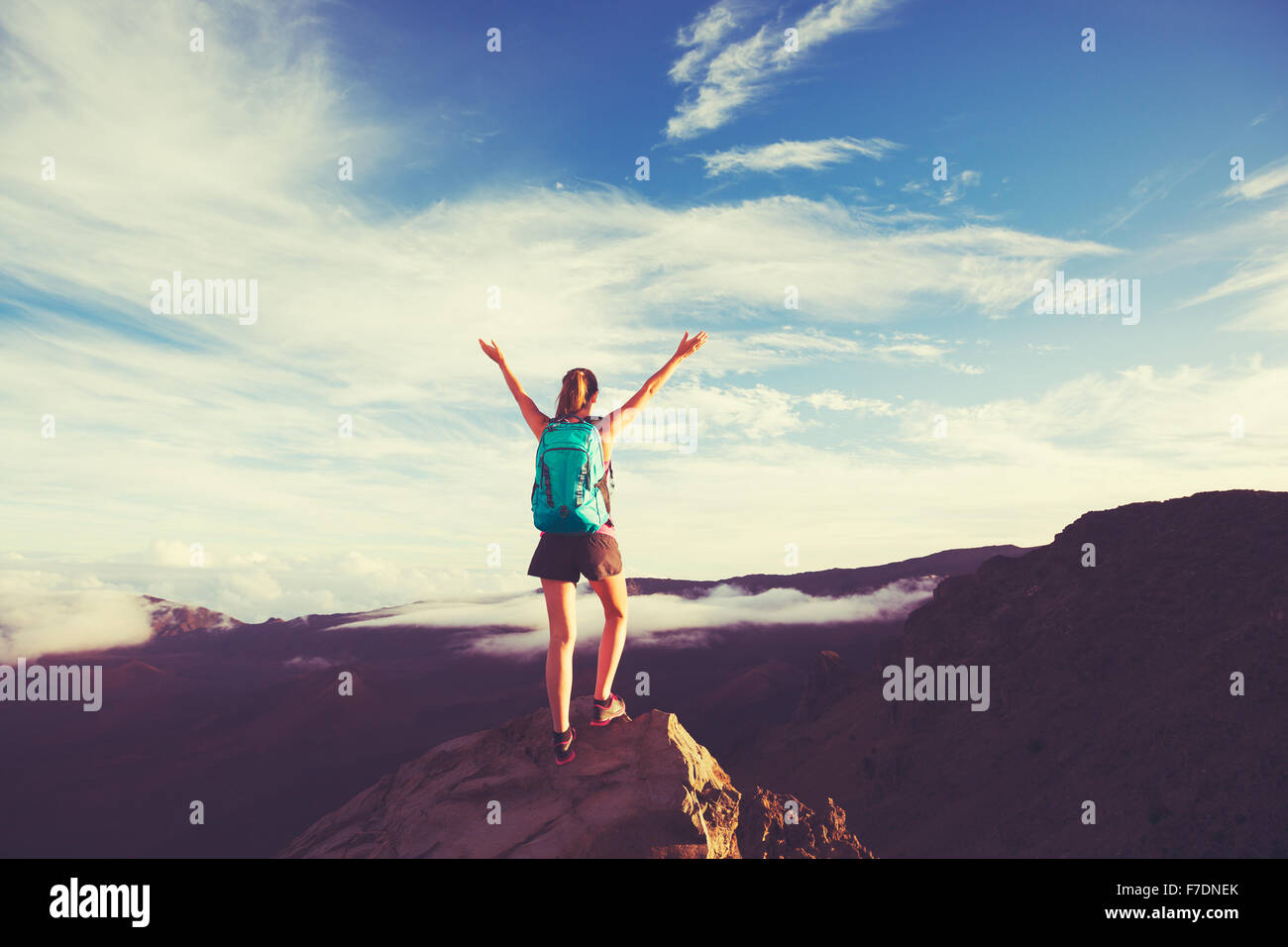 Young happy woman hiker with backpack standing on mountain peak with ...