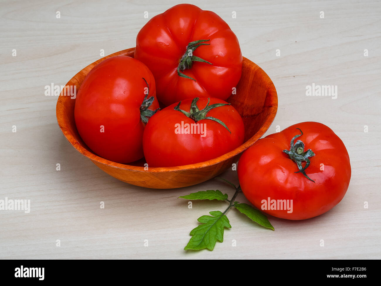 Red tomatoes in the basket with green branch Stock Photo - Alamy