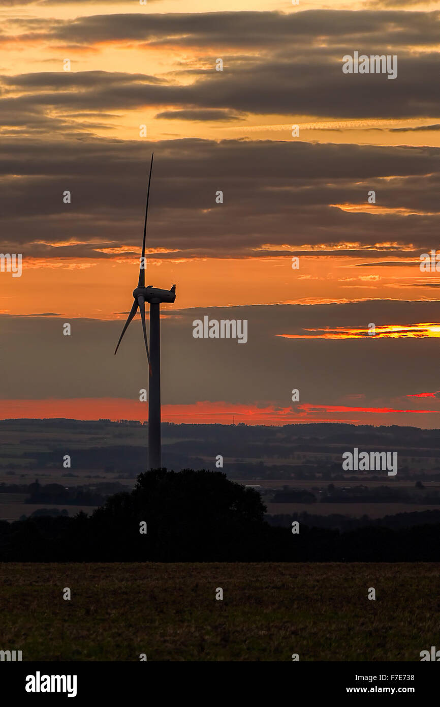 Wind power plant in sunset with dramatic sky. Stock Photo