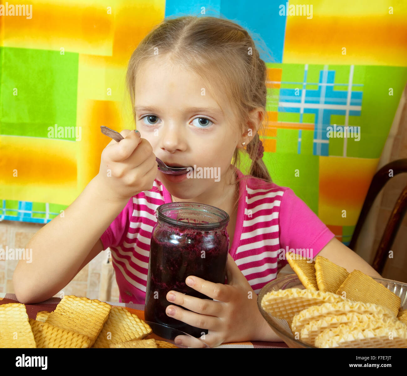 Little girl eating marmalade from glass jar at kitchen Stock Photo Alamy
