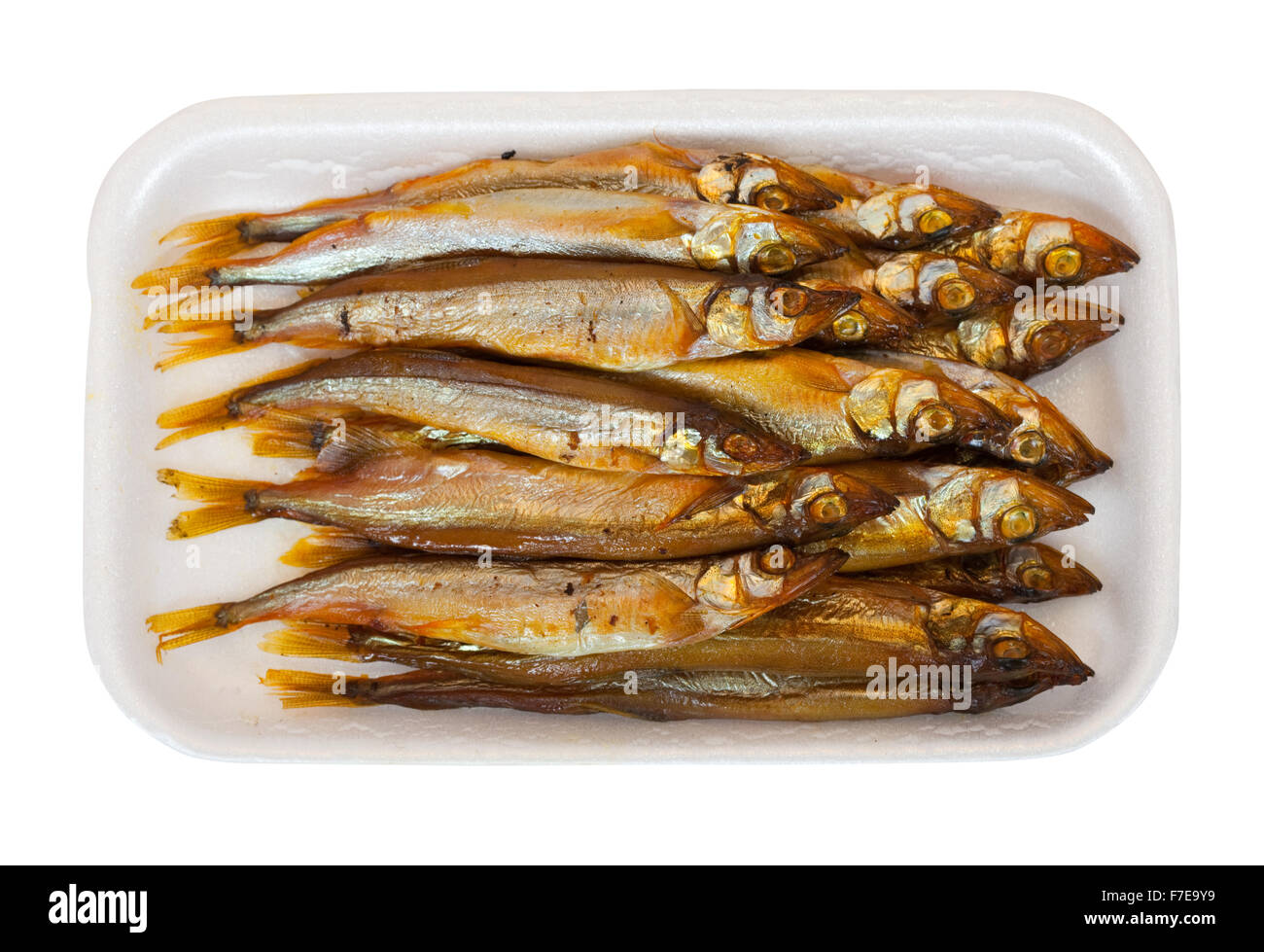 Golden smokedried fish in the plastic plate. Isolated on white Stock