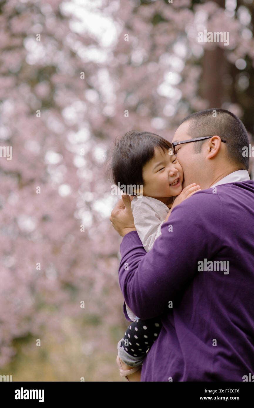 USA, Father kissing daughter (2-3) in park Stock Photo